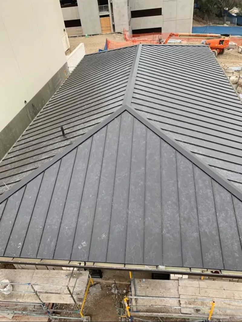 Commercial metal roof construction with crane equipment in Northfield